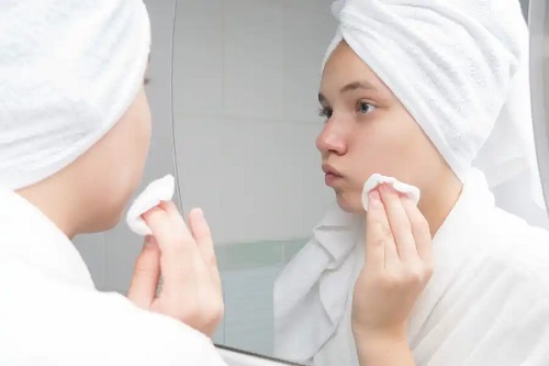 Fată care își curăță tenul