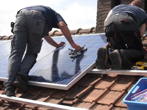 Specialiști care curăță panourile solare