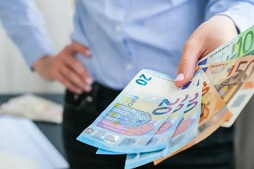 Bărbat care ține în mână bani