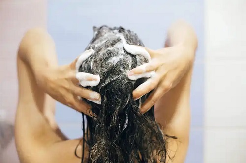 Femeie care folosește tratamentul cu acid hialuronic pentru păr