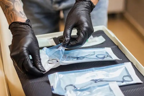 Specialist ce folosește instrumente pentru piercing