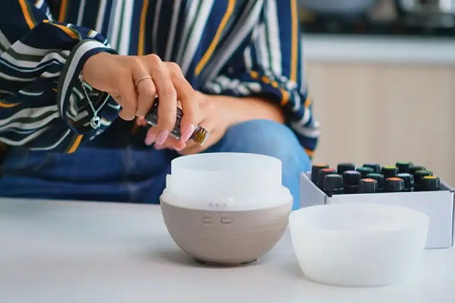 Femeie care folosește aromatizoarele pentru casă