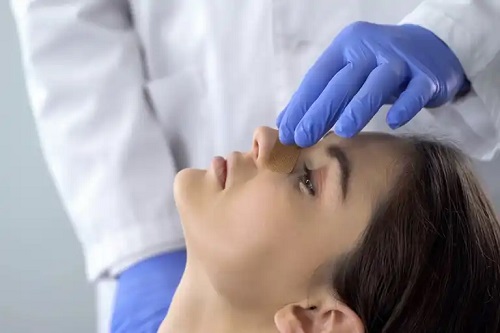 Medic care examinează nasul unei femei