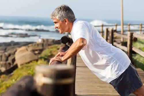 Bătrân care execută exerciții pentru masă musculară pentru bătrâni