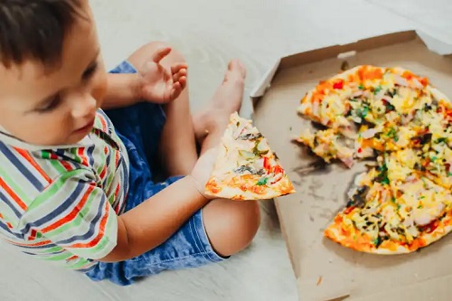 Copil care mănâncă pizza