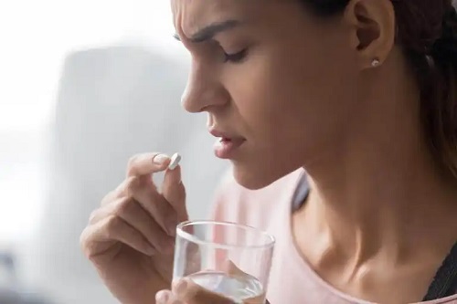 Fată care ia medicamente pentru durerile de spate