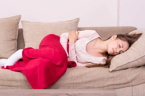 Fată afectată de oboseala menstruală