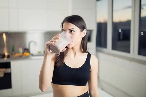 Fată care bea un shake proteic
