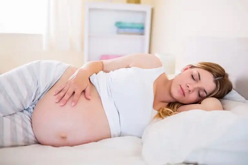 Femeie care cunoaște beneficiile pernei pentru gravide
