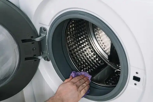 Persoană care elimină scamele din mașina de spălat