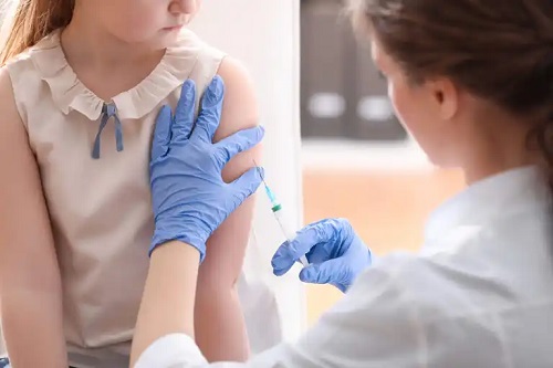 Medic ce face un vaccin unei fetițe