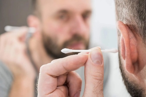 Bărbat care își curăță urechile