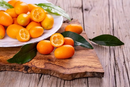 Fructe kumquat pe o placă din lemn