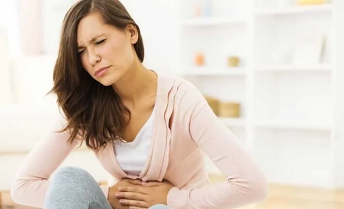 Femeie care experimentează durerile produse de gazele intestinale