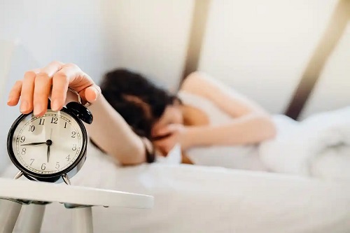Femeie care oprește alarma dimineața