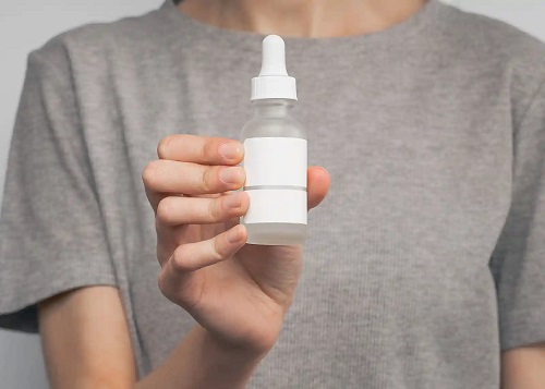 Femeie care folosește un ser pentru piele