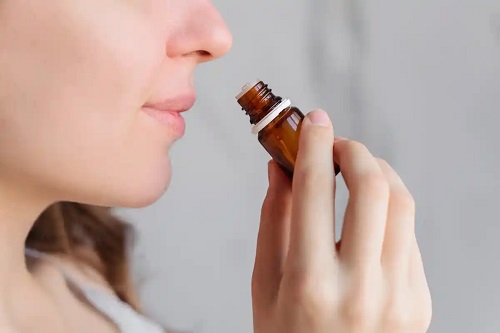 Femeie care miroase uleiul esențial de Helichrysum