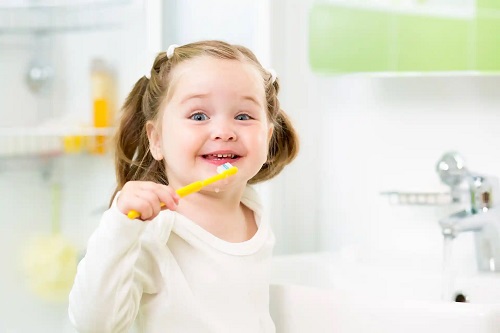Fetiță care se spală pe dinți