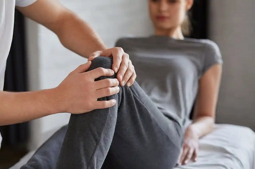 Fizioterapeut care tratează o leziune la genunchi