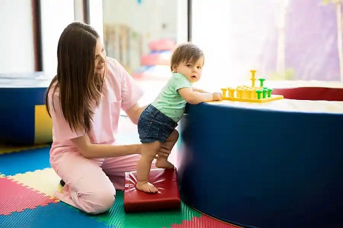 Terapeut care ghidează exerciții pentru întărirea brațelor copiilor