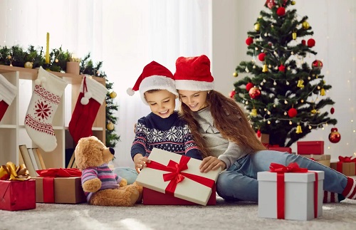 Copii care deschid cadouri de Crăciun