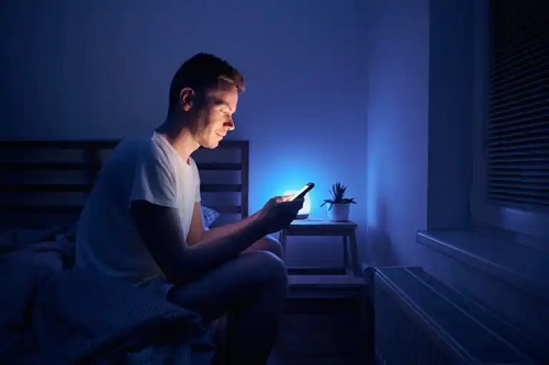 Bărbat care stă pe telefon noaptea