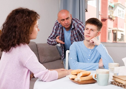 Părinți discutând cu un adolescent