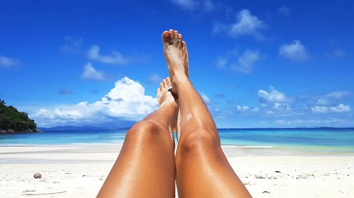 Picioare bronzate la plajă