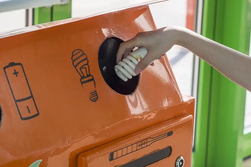 Persoană care reciclează becurile