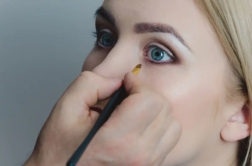 Femeie care folosește tehnica dot eyeliner