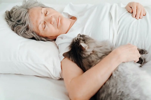 Femeie care apreciază dormitul cu pisica