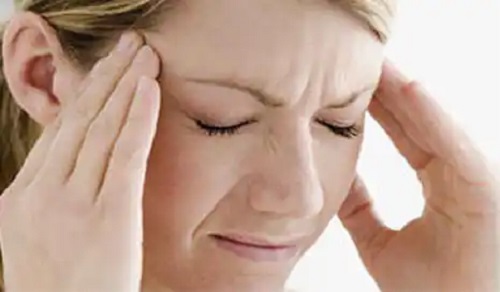 Femeie afectată de durerile de cap din cauza vremii