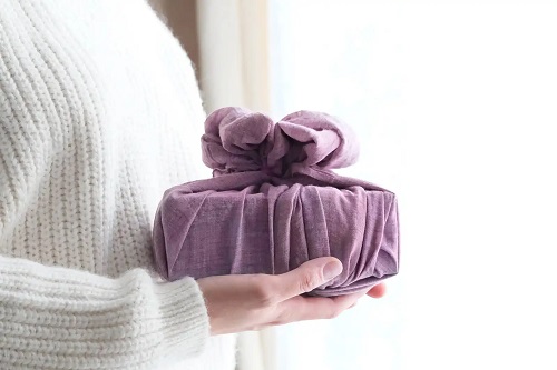 Femeie care a împachetat un cadou în stil Furoshiki