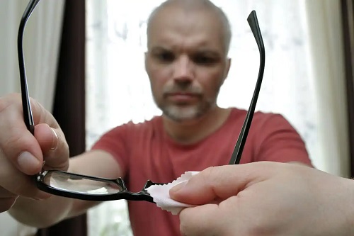 Bărbat care curăță ochelarii cu microfibră